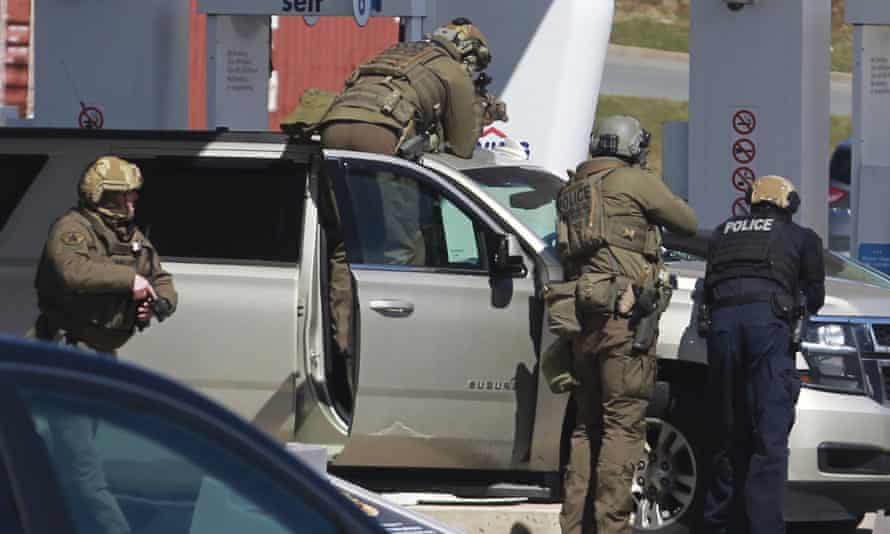 Royal Canadian Mounted Police officers surround a suspect at a gas station in Enfield, Nova Scotia.