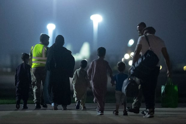 Passengers evacuated from Afghanistan disembark at RAF Brize Norton station in southern England, 24 August 2021.