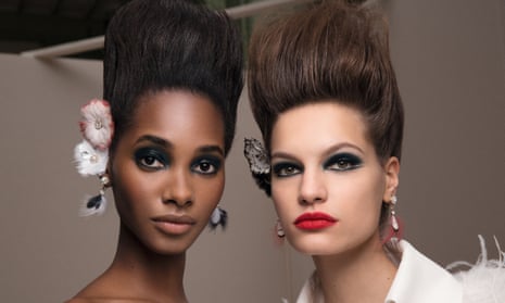 A black and a white model side by side, both with heavily made up eyes and lips