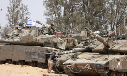 Israeli troops on and around a number of tanks with an Israeli flag visible.