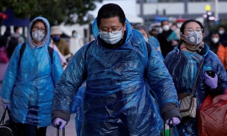 People wear face masks and plastic raincoats as a protection from coronavirus in Shanghai.