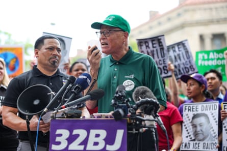 a man speaks into a microphone in front of a crowd of people