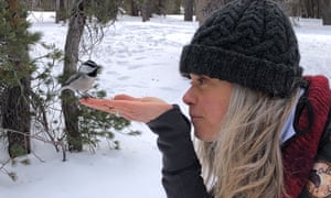 Woniya Thibeault with a chickadee on her hand.