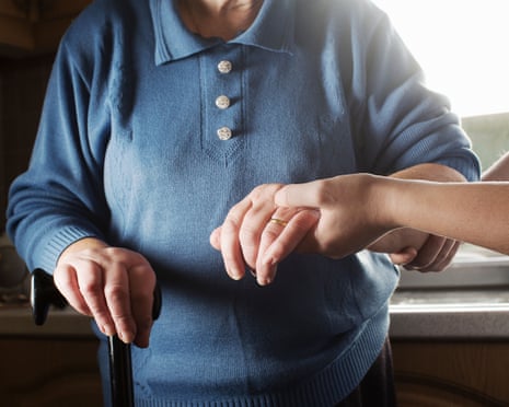 An elderly woman being assisted by a care worker