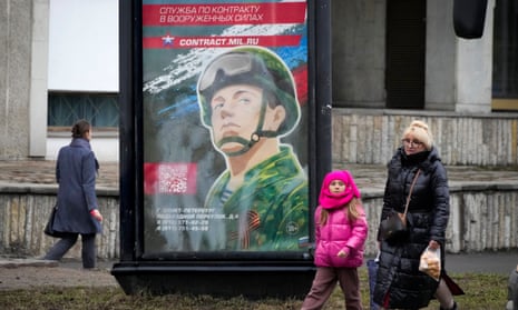 People walk past an army recruiting billboard in St. Petersburg, Russia.