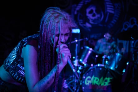 Vic Morphine, vocalist of Repressão Social, sings into a microphone on stage.
