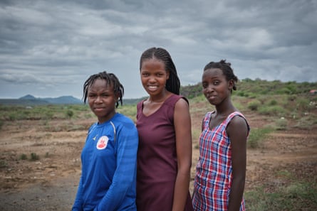 Three girls in front of an arid landscape