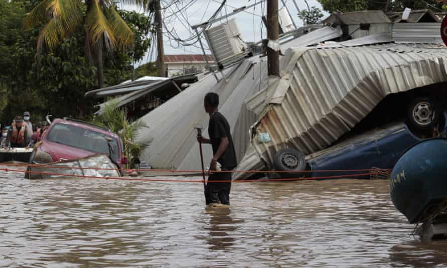 A man walks through a flooded street caused by Hurricane Eta in Planeta, Honduras, in 2020