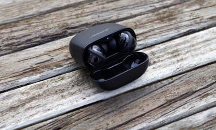 The Bose QuietComfort Ultra earbuds in their case on a table.