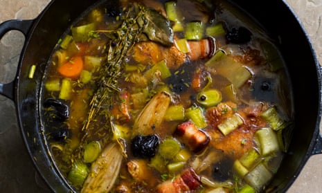 A large round black iron pot of  chicken, leek and prune broth