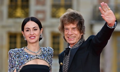 Mick Jagger waves next to Melanie Hamrick