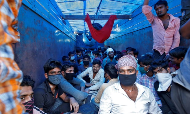 Migrant workers in Ahmedabad crowd into a lorry to return to their villages at the start of India’s 21-day nationwide lockdown