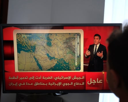 A person watches a TV broadcast on the latest developments in the Middle East after Houthis’ missile attack on Israel.