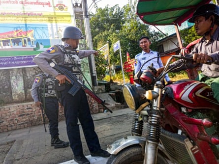 Armed policemen at a roadside checkpoint during the visit of the Myanmar junta leader Min Aung Hlaing to Thanlyin township, on the outskirts of Yangon on 24 December 2022.