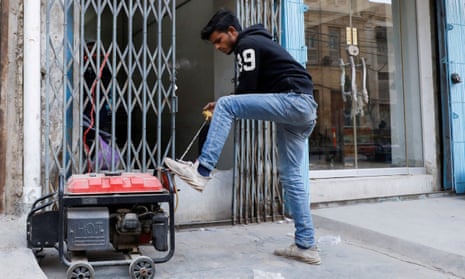 A man starts a generator outside his shop in Karachi, Pakistan during a country-wide power breakdown.