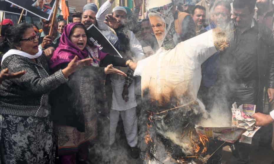 Congress party supporters in Amritsar burn an effigy of Narendra Modi during a demonstration to protest against the violence occurring in Delhi