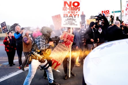 protesters stand outside by vehicle, some holding sign such as ‘no ice or troops in the b