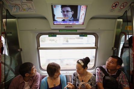 Train passengers in Hong Kong are shown TV images of Edward Snowden before his flight to Moscow in June 2013.