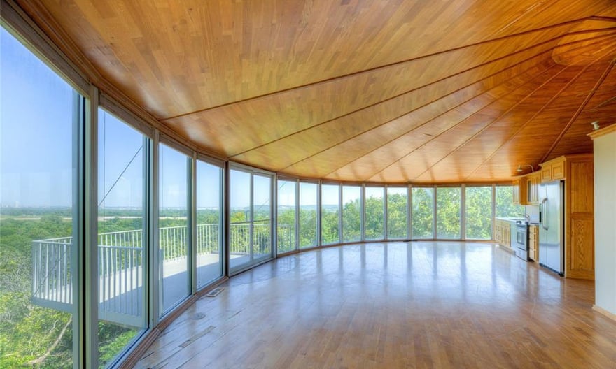 windows all along the side of the house look out on to balcony and trees