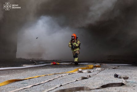 A firefighter works amid black smoke after an attack