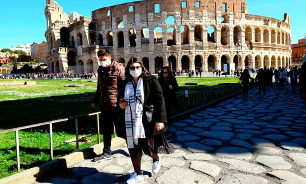 Tourists wearing face masks outside the Colosseum in Rome