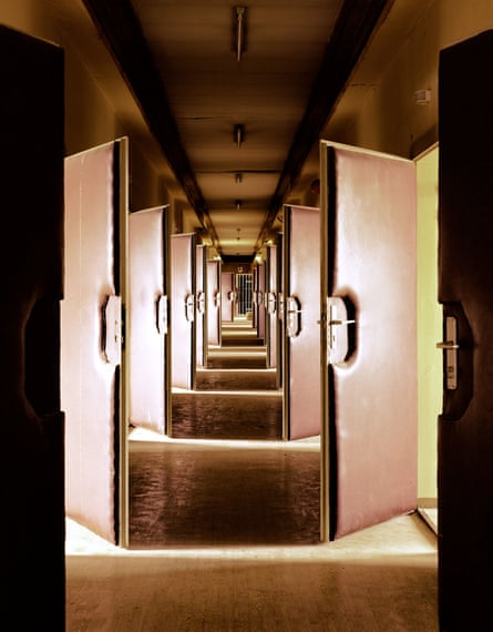 A long corridor with many doors on either side open