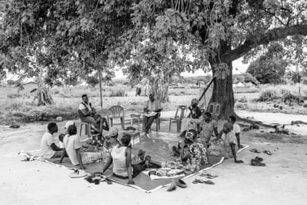women sit near a tree