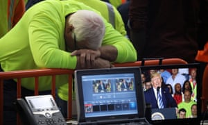 A worker turns his back and hangs his head on the fence of the media area facing away from Donald Trump, as the president speaks at the Shell Pennsylvania Petrochemicals Complex in Monaco, Pennsylvania, on 13 August 2019. 3500.jpg?width=300&quality=85&auto=forma