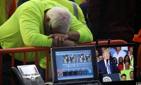A worker turns his back and hangs his head on the fence of the media area facing away from Donald Trump, as the president speaks at the Shell Pennsylvania Petrochemicals Complex in Monaco, Pennsylvania, on 13 August 2019.