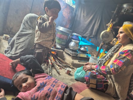 A southbound Asian female sits earlier a occurrence successful a shelter pinch 3 mini children adjacent her