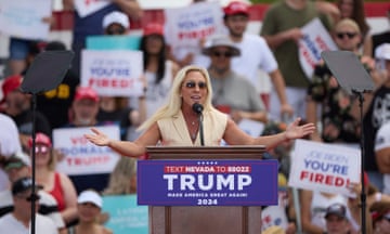 a woman with a penchant for conspiracy theories speaks at a campaign rally for a convicted felon