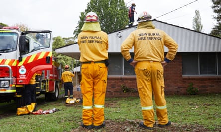 NSW Rural Fire Service workers repair the damage to a Sydney house after the city was hit by a hailstorm.