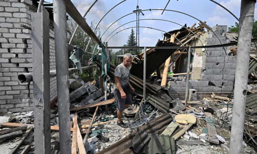 A resident walks among debris next to a destroyed house in Sloviansk on 4 July.