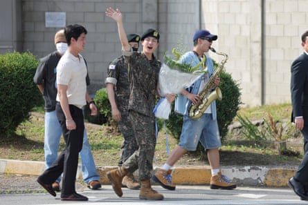 K-pop band BTS’s member Jin, center, waves after being discharged from mandatory military service
