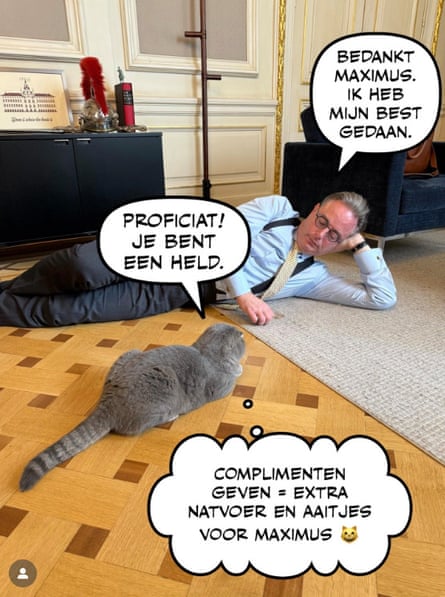‘Congratulations, you are a hero!’ Maximus tells De Wever, who is lying on the floor in the living room facing his cat.