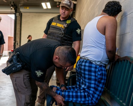 Troopers put shackles on an immigrant
