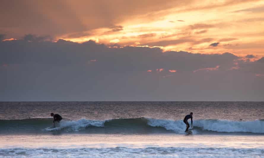 Evening surfers enjoy Llangennith beach in Rhossili Bay.