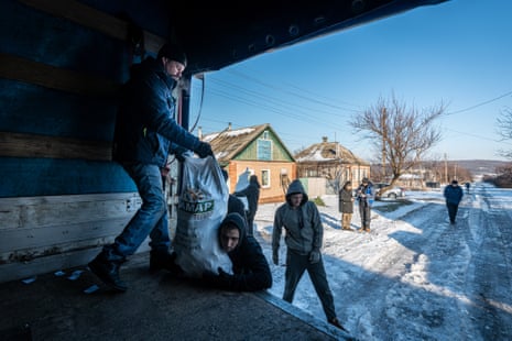 Ukrainian volunteers unload bags with fuel briquettes at the home of civilians, in Donetsk oblast, Ukraine on Wednesday.