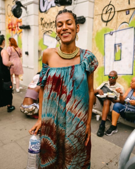 Anna smiling at the camera with her eyes closed and a bottle of water in her hand