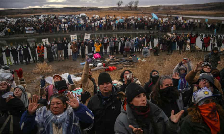 Anti-pipeline protesters raise their arms during a prayer at the Standing Rock reservation in North Dakota. 