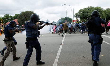 South African riot police fire rubber bullets during clashes between South African and foreign national protesters on Friday.
