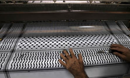 A worker cuts excess strings at a textile factory producing the keffiyeh in the occupied West Bank city of Hebron last month.