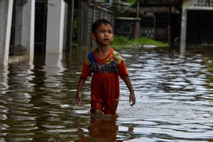 A child wades through flood water in Ajun, Indonesia