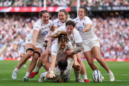 England players flock to celebrate after Zoe Harrison scores her fourth try against New Zealand.