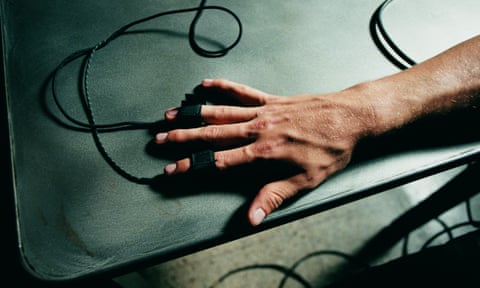 Person’s hand hooked up to polygraph test, lie detector close-up (Overhead view)