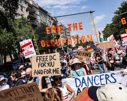 Demonstrators hold banners with slogans including: ‘Free DC for you and me’ and ‘End the occupation’
