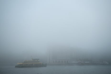 A ferry moves through thick fog.