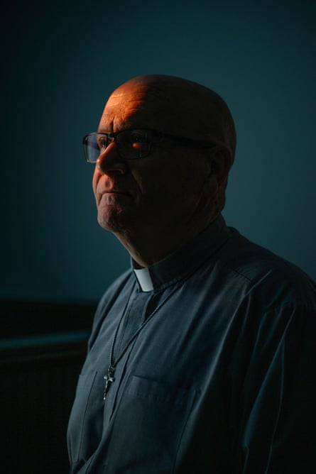 portrait of a man wearing a priest's dog collar and crucifix