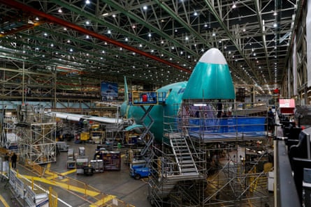 Scene inside factory of 747 surrounded by scaffolding and workers