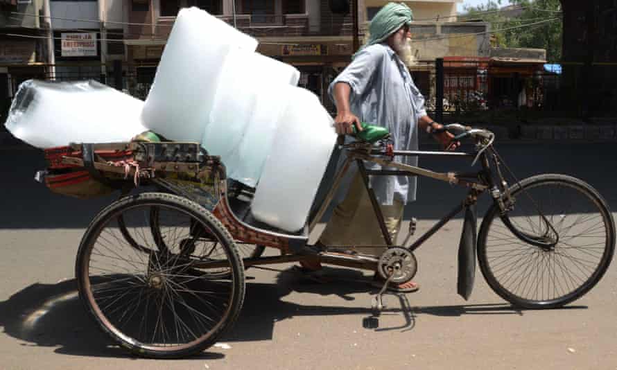 A man uses a rickshaw to transport ice from a factory in Amritsar
